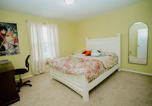 a bedroom with a bed chair and window