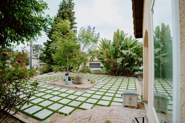 a patio with table and chairs and potted plants