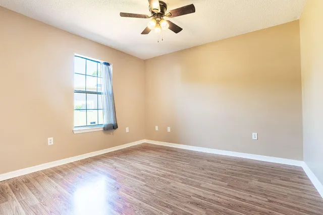 wooden floor in an empty room with a window