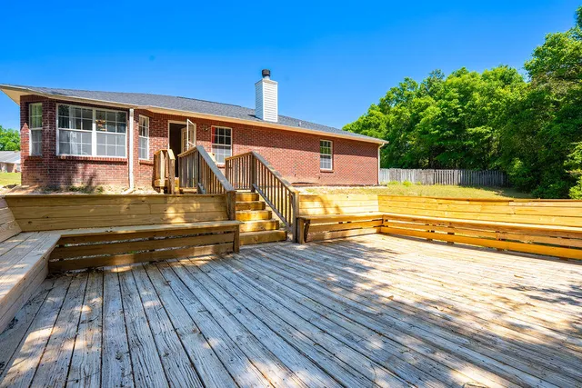 a view of a roof deck with wooden floor and fence