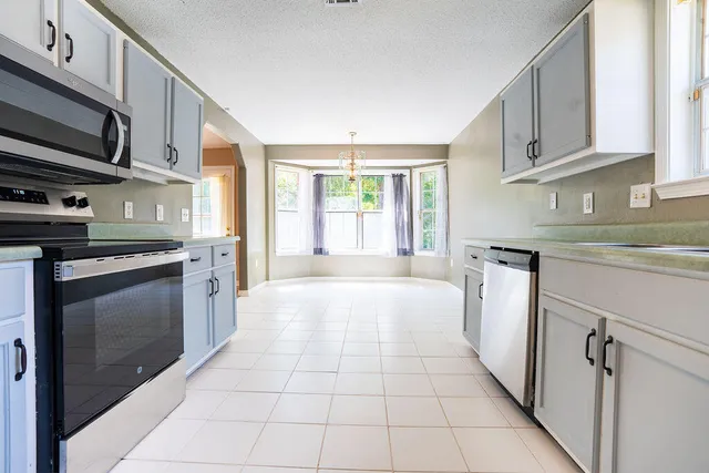 a kitchen with stainless steel appliances granite countertop a stove a sink and a microwave
