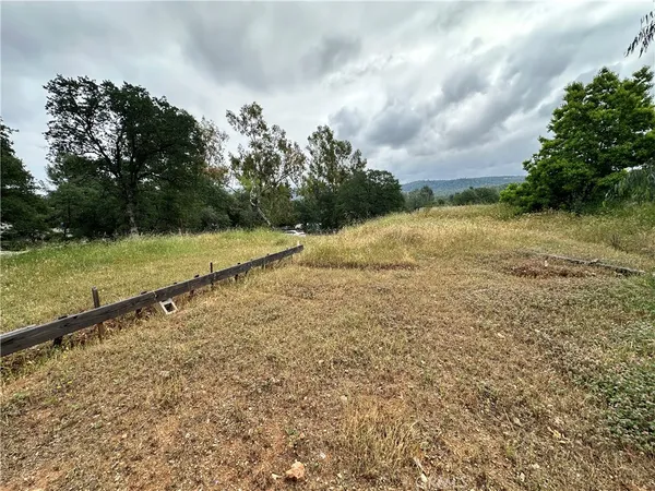 a view of a yard with wooden fence