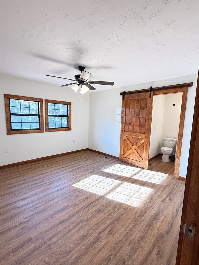 157 Old Loving Road Mineral Bluff, GA 30559 - Photo 2 of 10 a view of an empty room with a window and wooden floor