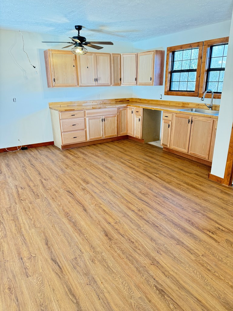 157 Old Loving Road Mineral Bluff, GA 30559 - Photo 9 of 10 a kitchen with granite countertop white cabinets and wooden floor