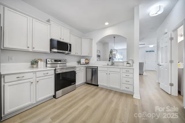 a kitchen with white cabinets stainless steel appliances and sink