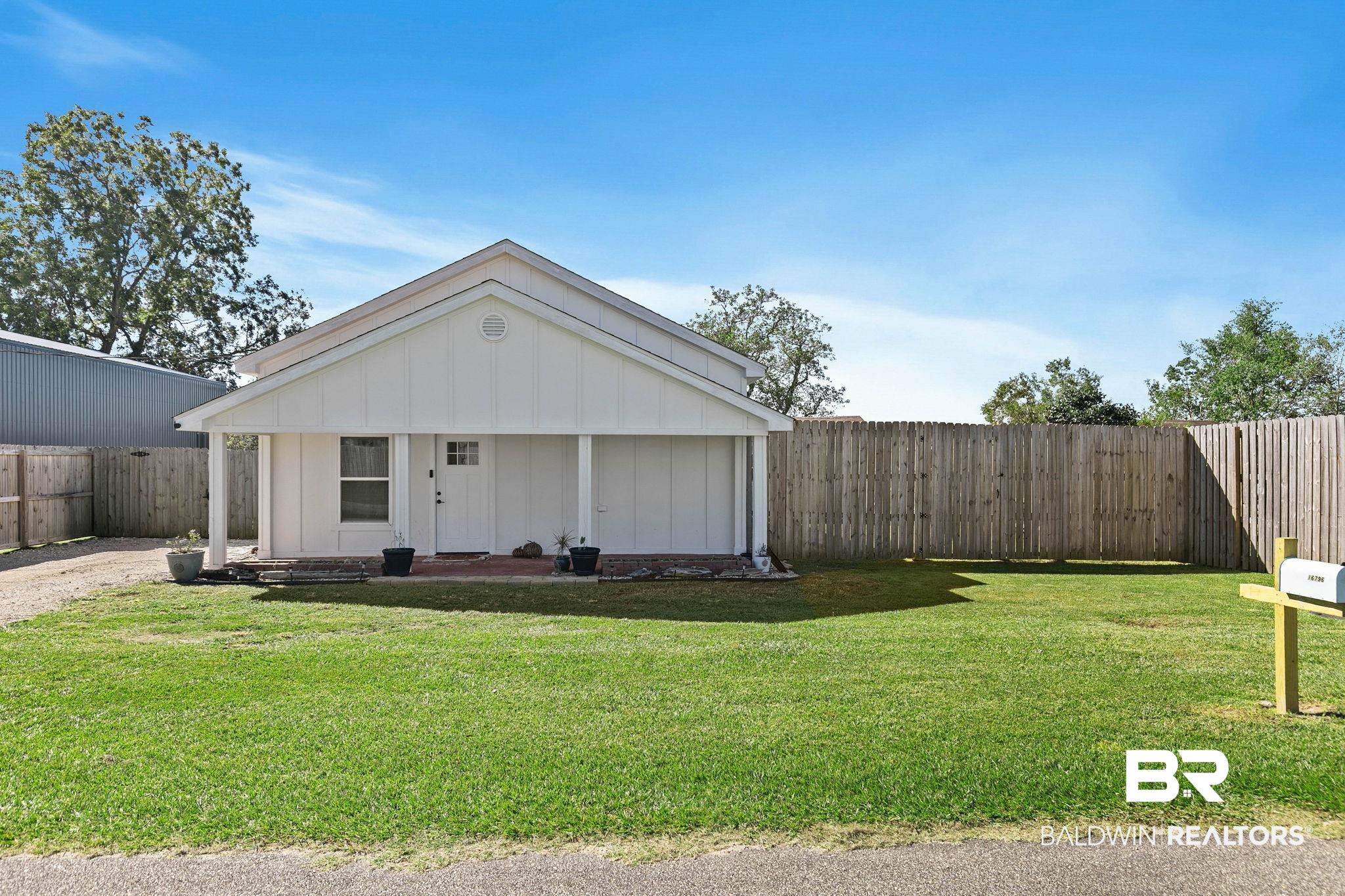 16796 Thompson Road Loxley, AL 36551 - Photo 5 of 93 View of front of property featuring board and batten siding, a fenced backyard, and covered porch