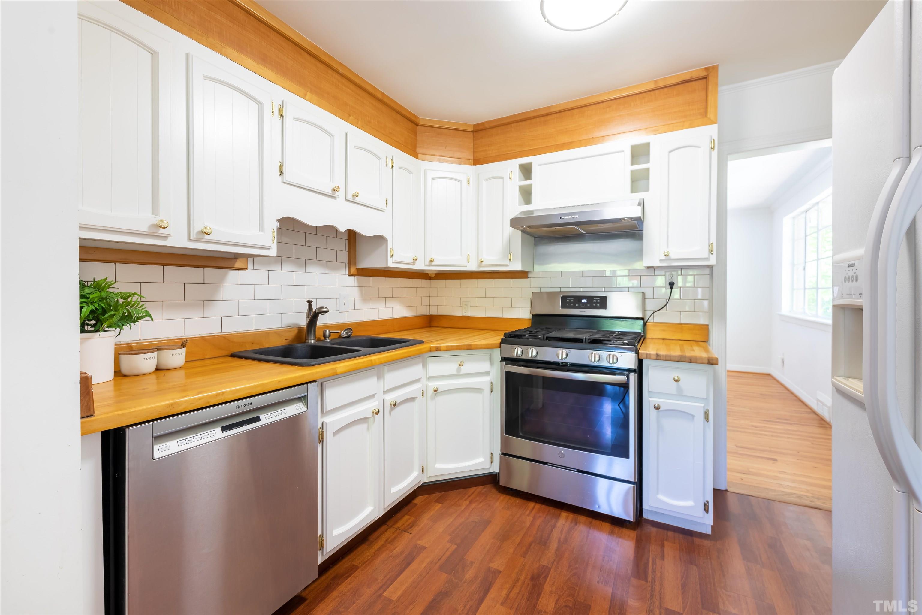 1433 Chester Road Raleigh, NC 27608 - Photo 18 of 33 a kitchen with stainless steel appliances a stove a sink and a microwave