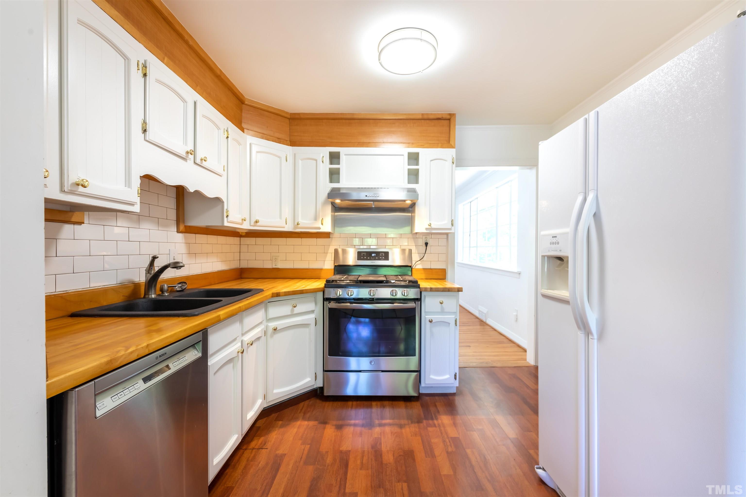 1433 Chester Road Raleigh, NC 27608 - Photo 19 of 33 a kitchen with stainless steel appliances a stove a sink and a refrigerator