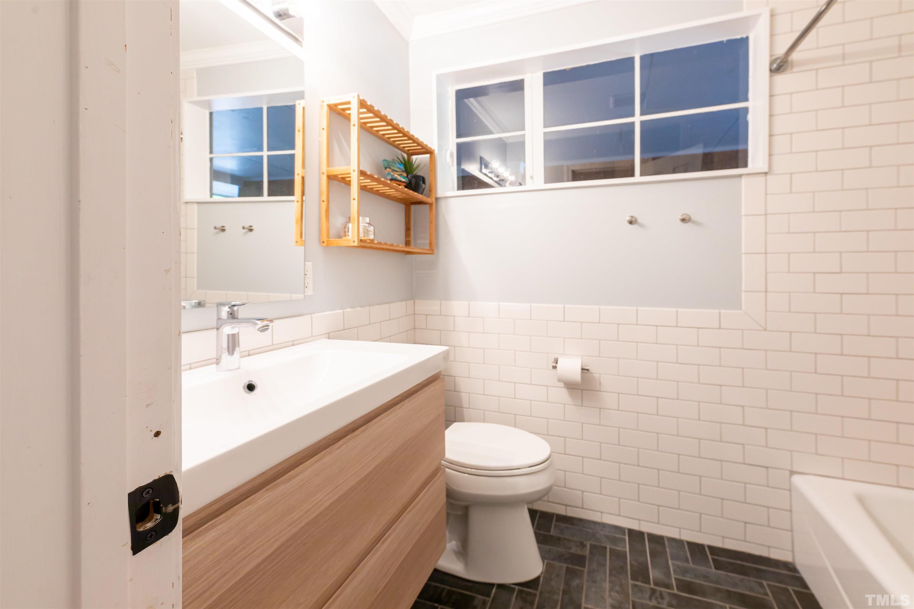 1433 Chester Road Raleigh, NC 27608 - Photo 32 of 33 a bathroom with a sink mirror vanity and toilet