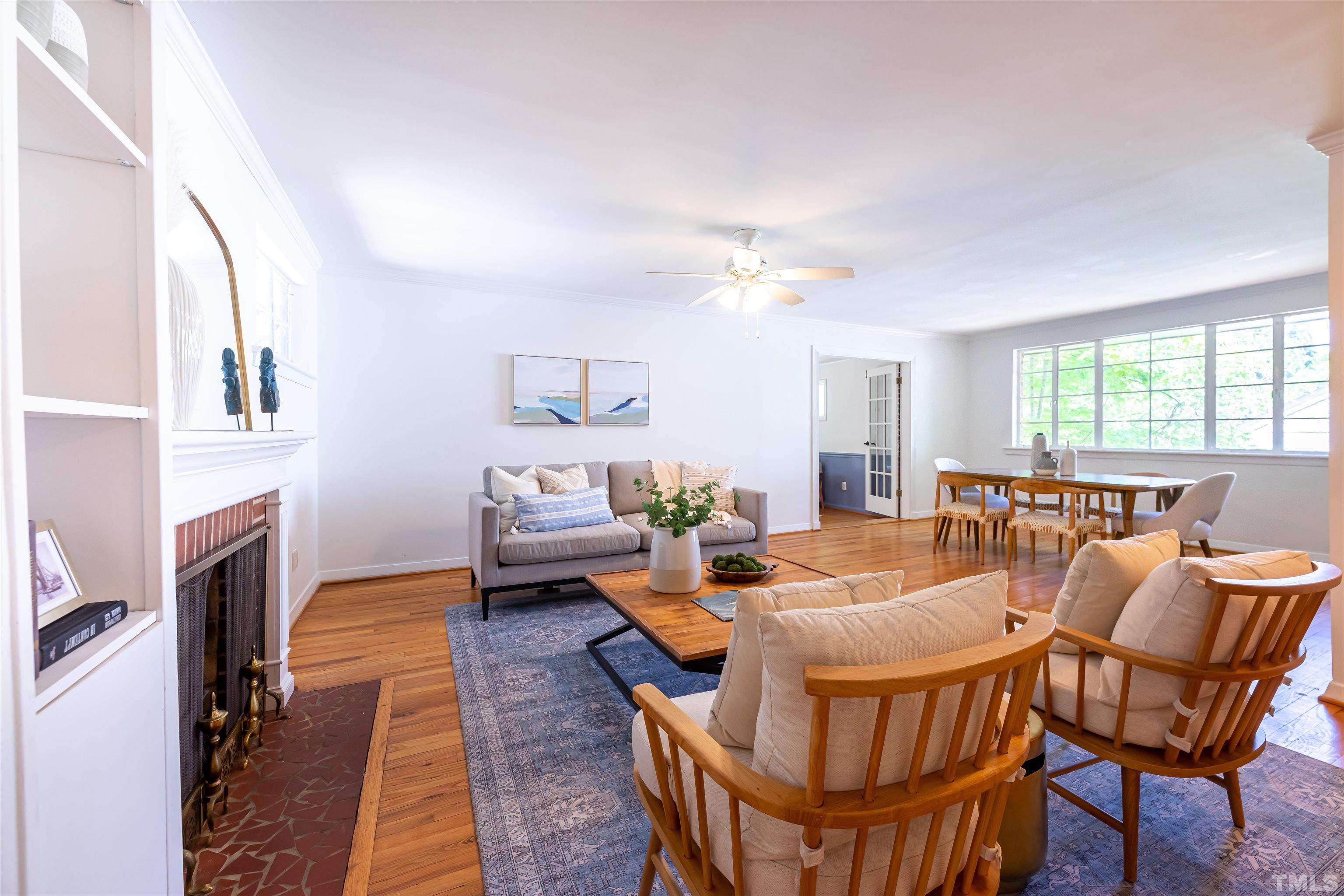1433 Chester Road Raleigh, NC 27608 - Photo 7 of 33 a living room with furniture a fireplace and a chandelier