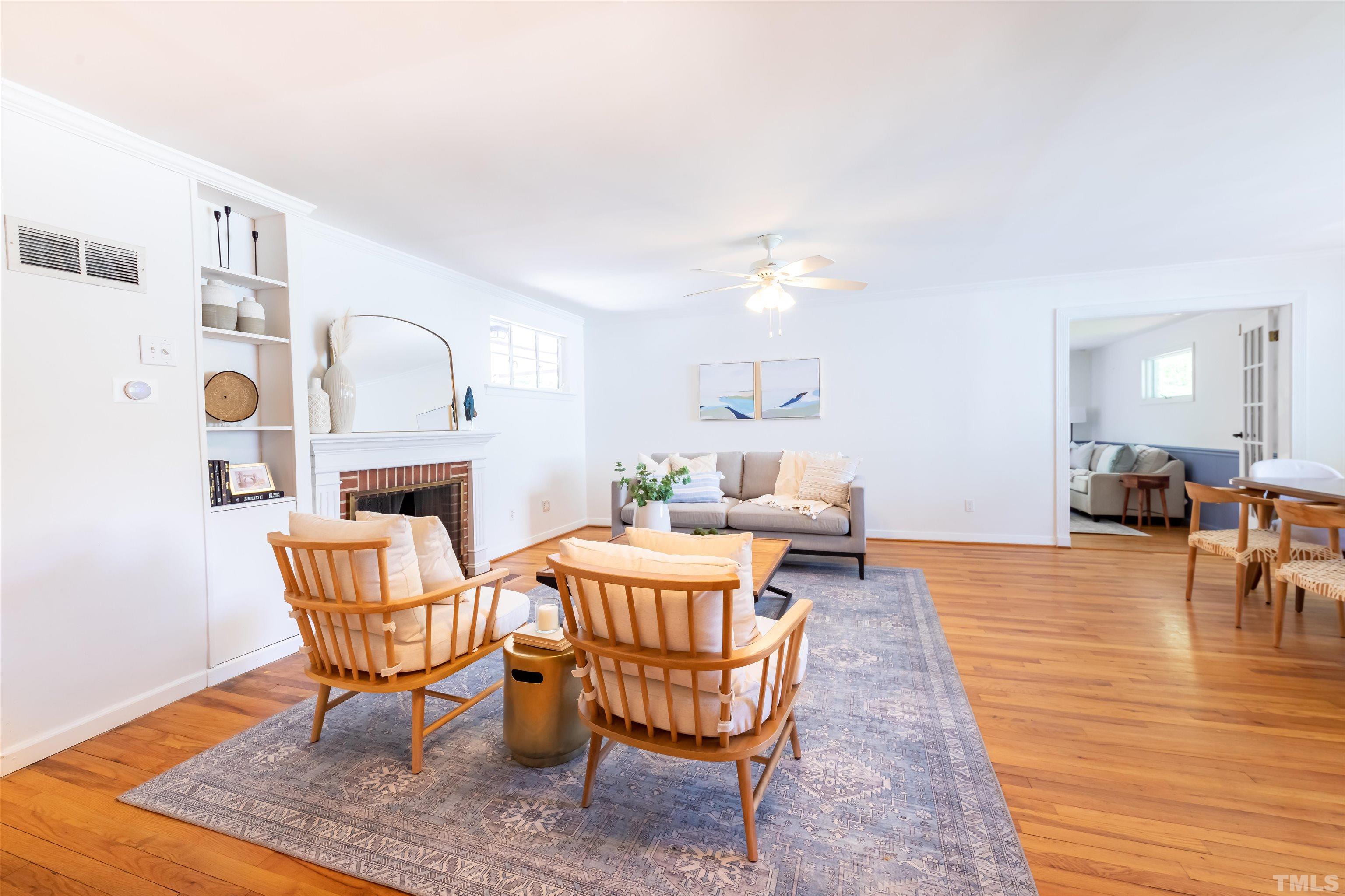1433 Chester Road Raleigh, NC 27608 - Photo 10 of 33 a living room with furniture and a dining table with wooden floor