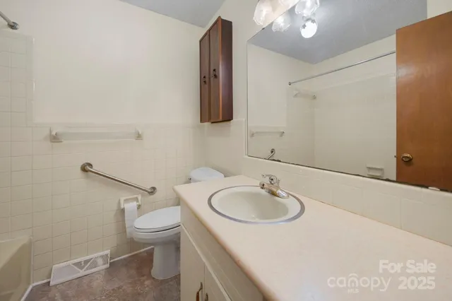 a bathroom with a sink a toilet and mirror