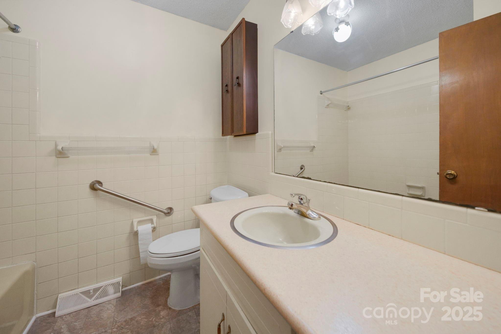 201 Smith Street, Unit 13 Wingate, NC 28174 - Photo 12 of 46 a bathroom with a sink a toilet and mirror