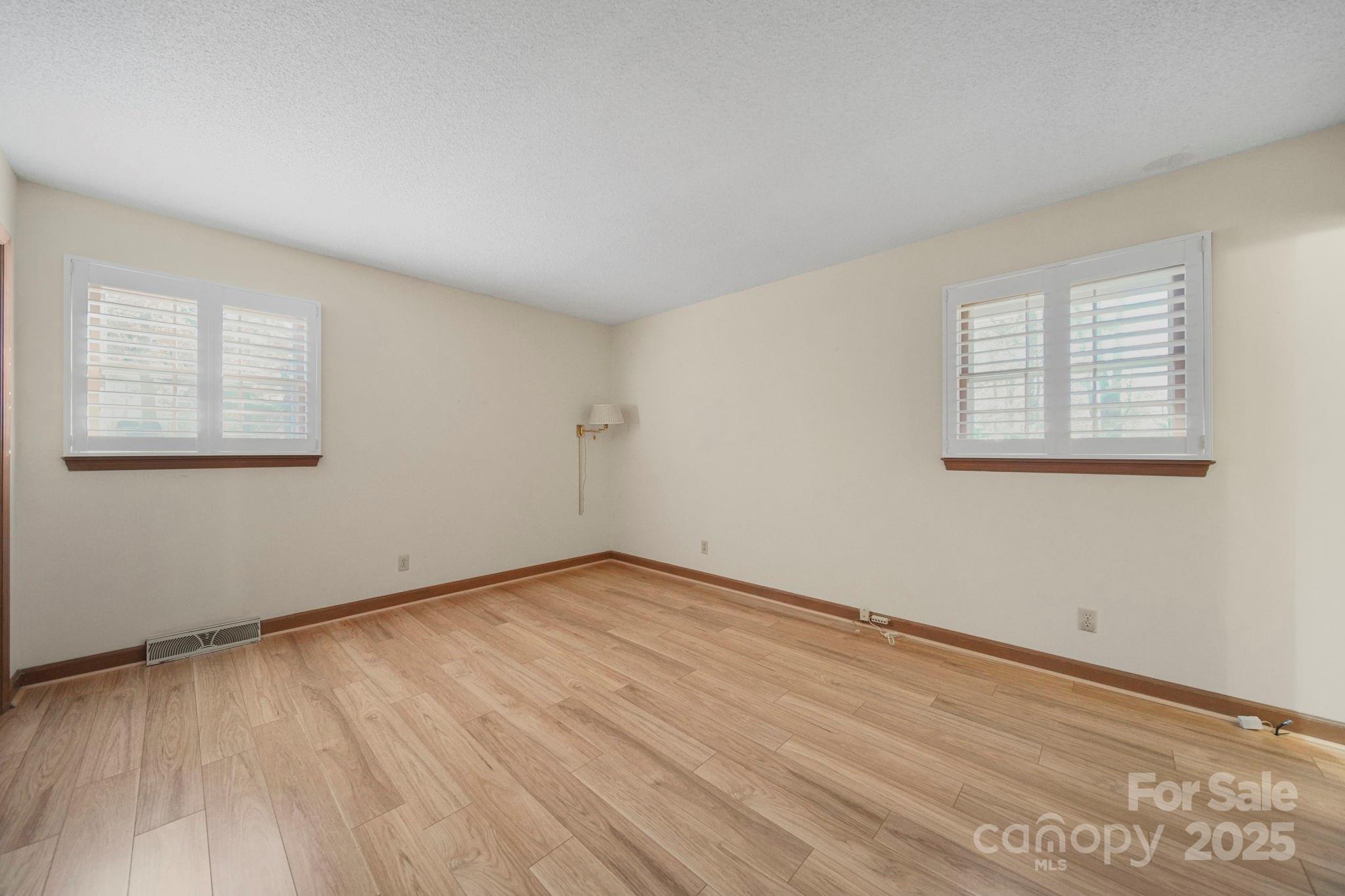 201 Smith Street, Unit 13 Wingate, NC 28174 - Photo 13 of 46 an empty room with wooden floor and windows