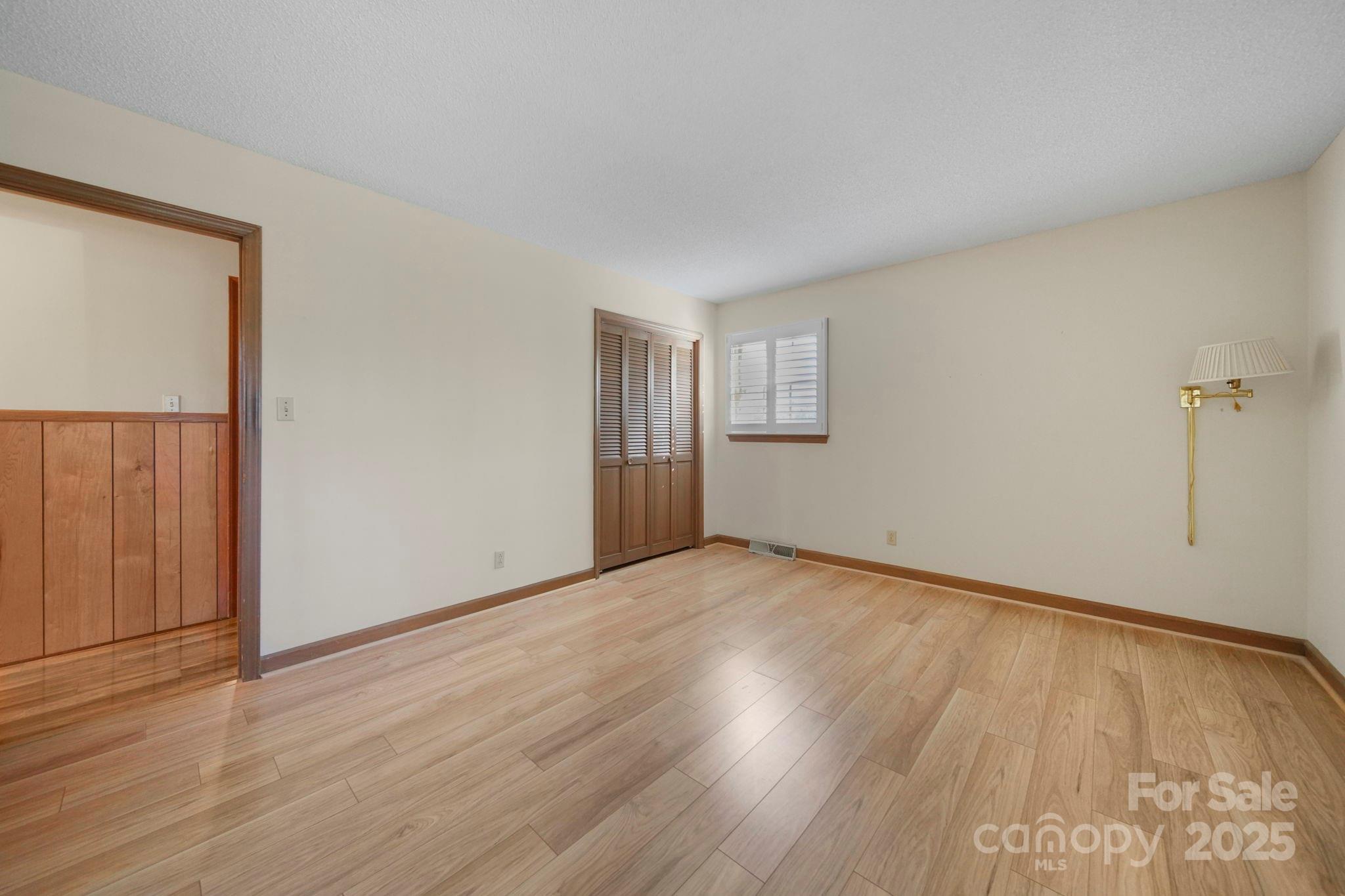 201 Smith Street, Unit 13 Wingate, NC 28174 - Photo 16 of 46 an empty room with wooden floor and windows