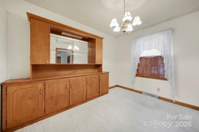 a view of a room with wooden floor and chandelier