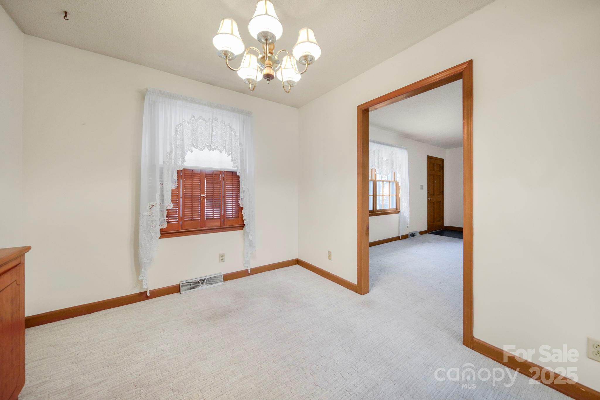 201 Smith Street, Unit 13 Wingate, NC 28174 - Photo 29 of 46 an empty room with chandelier fan and windows