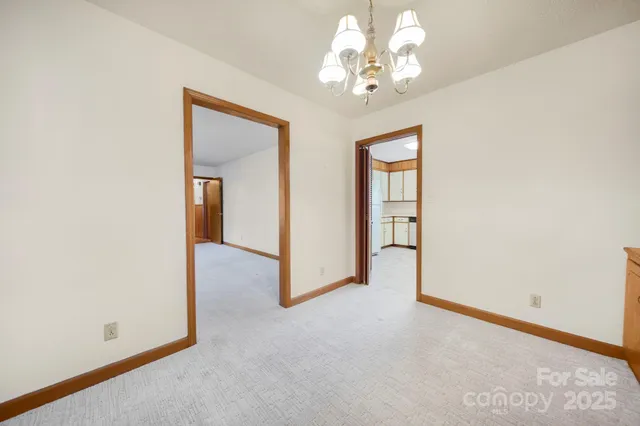 an empty room with chandelier fan