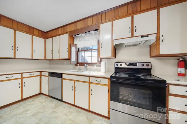 a kitchen with granite countertop cabinets stainless steel appliances and a sink