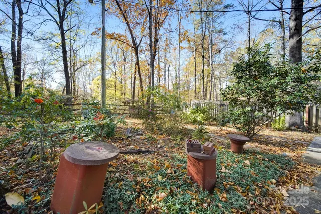 a backyard of a house with large trees and outdoor seating