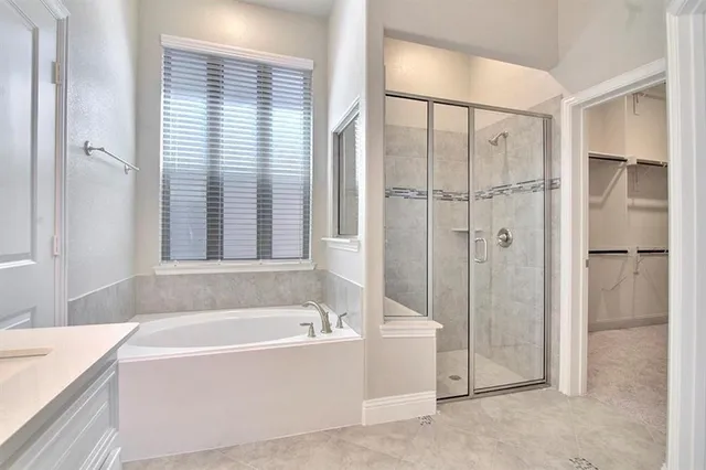 a large white kitchen with kitchen island a sink stainless steel appliances and cabinets