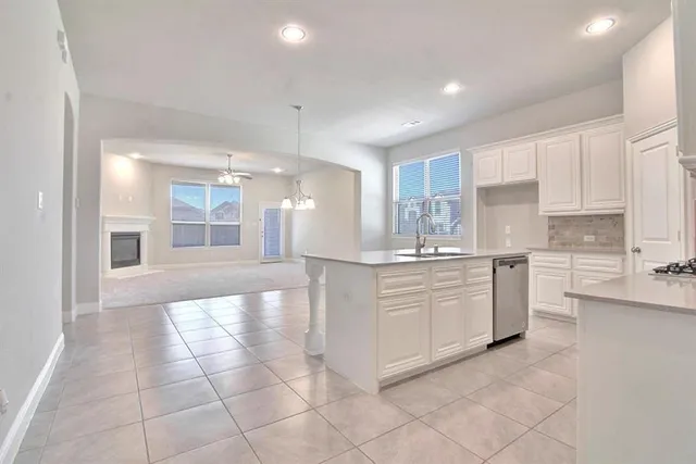 a kitchen with kitchen island granite countertop white cabinets and stainless steel appliances