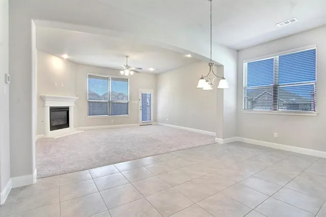 a view of an empty room and kitchen view