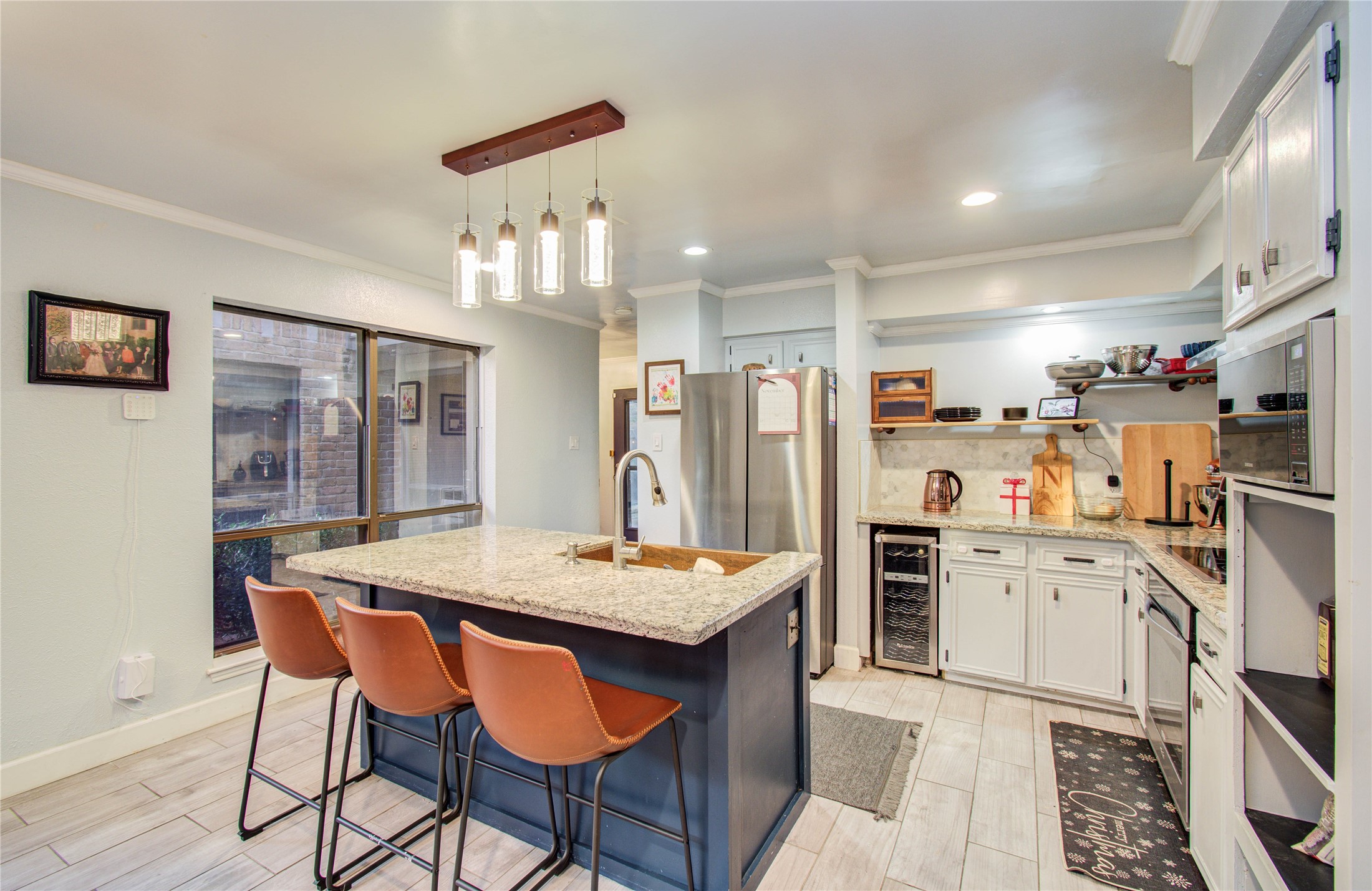 16707 Fernwood Way Houston, TX 77058 - Photo 15 of 46 a kitchen with stainless steel appliances kitchen island granite countertop a dining table and chairs
