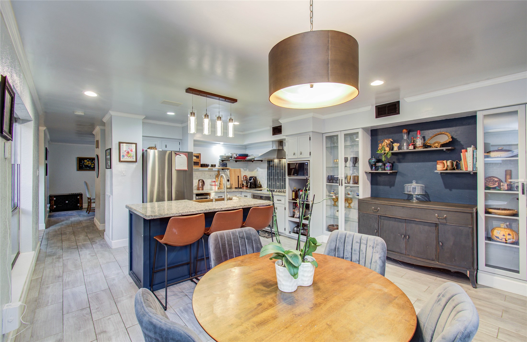 16707 Fernwood Way Houston, TX 77058 - Photo 16 of 46 a kitchen with stainless steel appliances kitchen island granite countertop a table chairs and a refrigerator