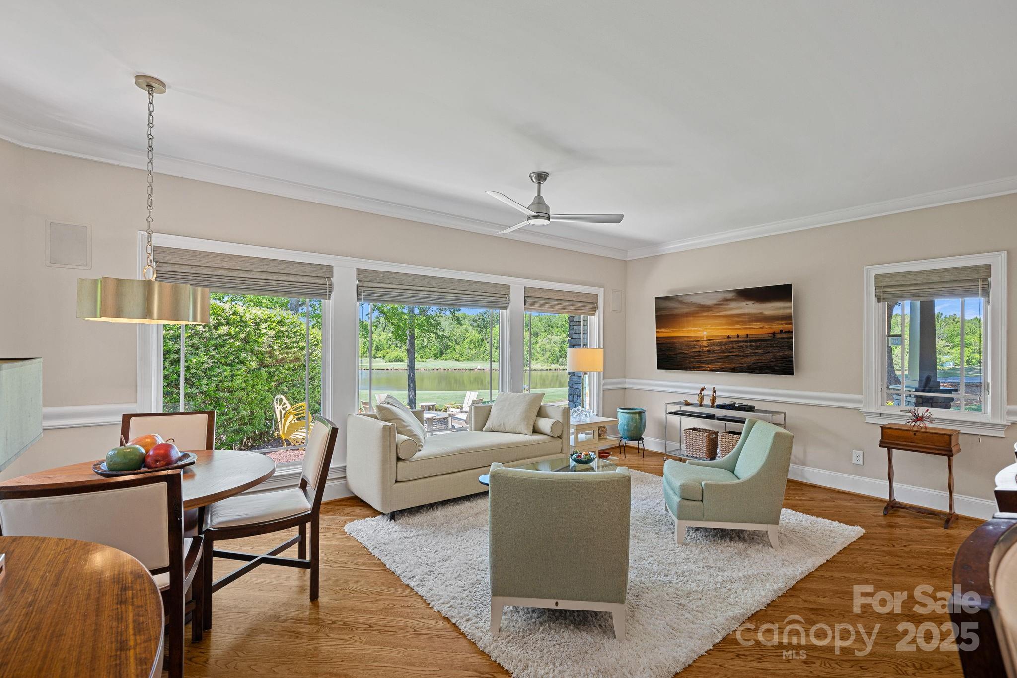 19501 River Falls Drive Davidson, NC 28036 - Photo 16 of 47 a living room with furniture floor to ceiling window hardwood floor and a flat screen tv