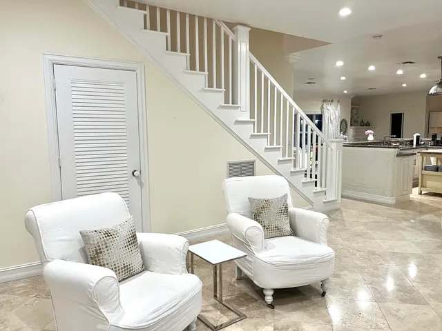 a living room with furniture and a white wall painting