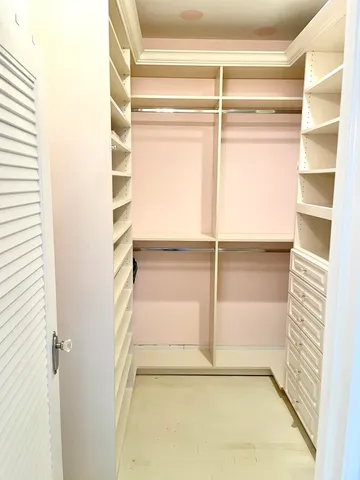 a view of walk in closet with empty racks