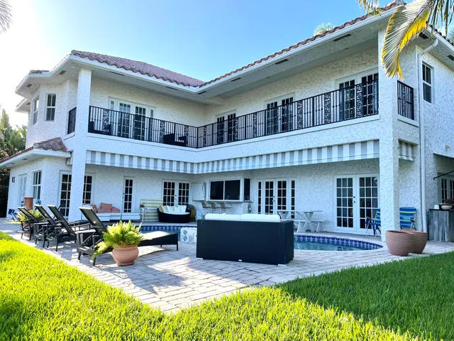 a view of a house with swimming pool and sitting area