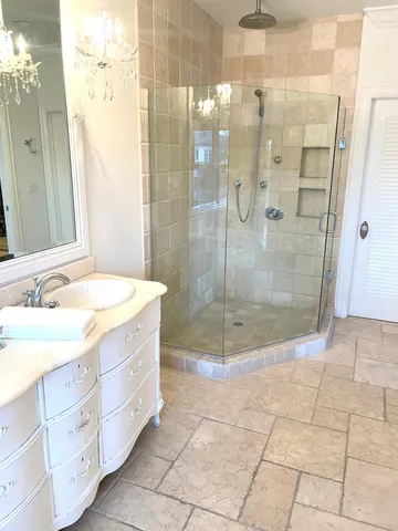 a bathroom with a shower and a sink a mirror