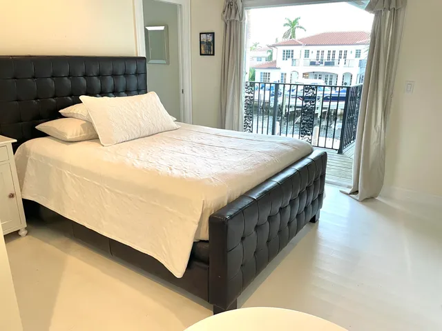 a bed sitting in a bedroom next to a window