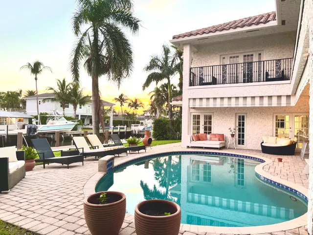 a view of a house with backyard and sitting area