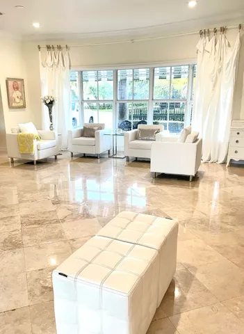 a living room with couches and kitchen view with wooden floor