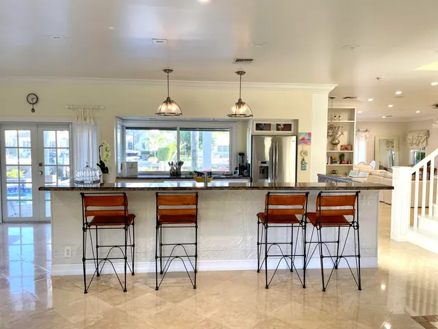 a living room with couches and kitchen view with wooden floor