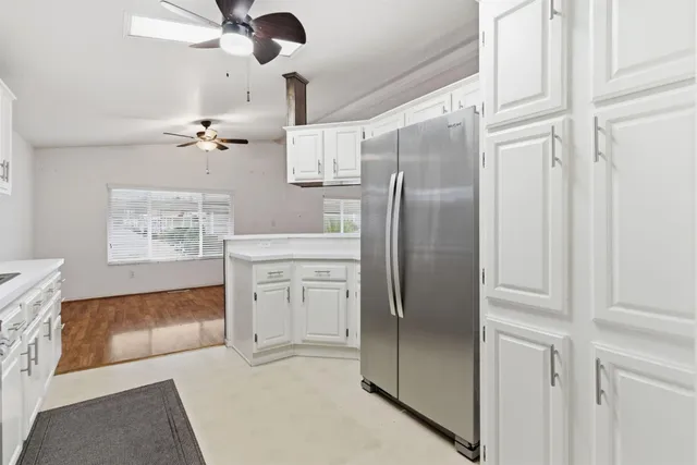 a kitchen with stainless steel appliances granite countertop a refrigerator and a stove top oven