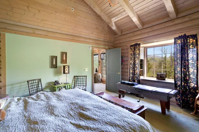 a bedroom with a bed and large windows