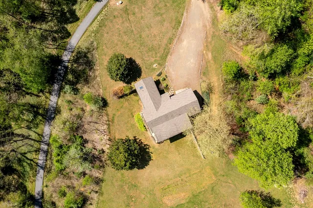 an aerial view of a houses with a lush green hillside