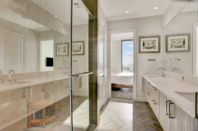 a bathroom with a double vanity sink mirror and bathtub
