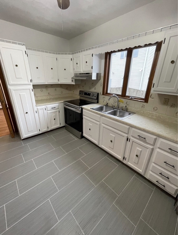 13 Jacobs Street, Unit 1 Peabody, MA 01960 - Photo 4 of 11 a kitchen with stainless steel appliances a sink stove and cabinets