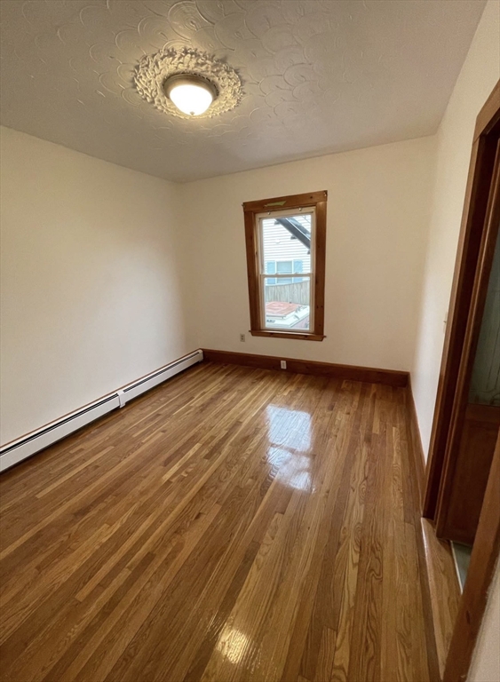13 Jacobs Street, Unit 1 Peabody, MA 01960 - Photo 7 of 11 an empty room with wooden floor and windows