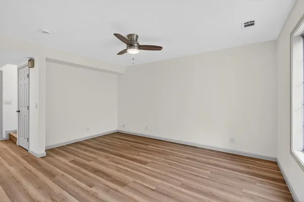 a view of empty room with wooden floor