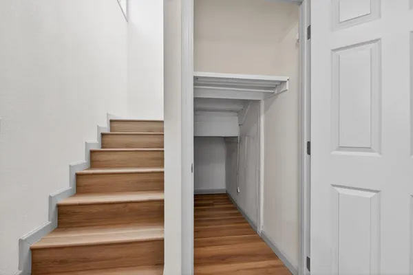 a view of a hallway with wooden floor and entryway