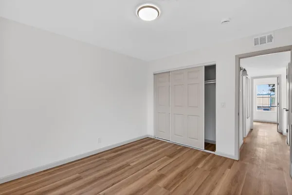 a view of a room with wooden floor and entryway