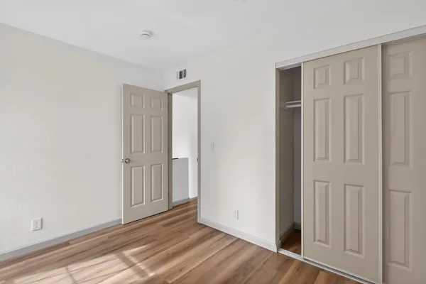 a view of an empty room with wooden floor