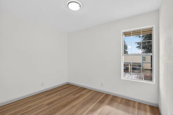 a view of a small space with wooden floor and a window
