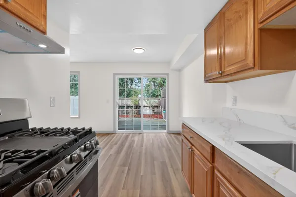 a kitchen with granite countertop stainless steel appliances a sink stove and cabinets